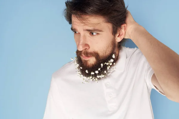 Bel homme dans un T-shirt blanc fleurs dans une barbe émotions — Photo