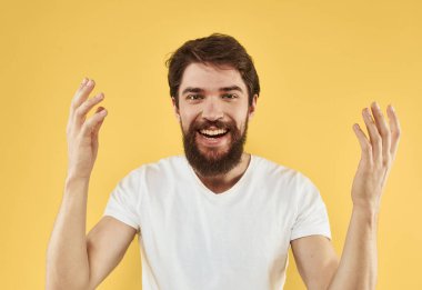 Enerjik adam elini kaldırdı ve sarı bir arka plan duygu modeli üzerinde durdu.