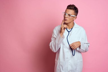 Erkek doktor beyaz önlük tedavisi pembe arka plan hastanesi