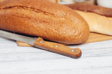 Ahşap bir masa üzerinde ekmek pişirme bıçağı.