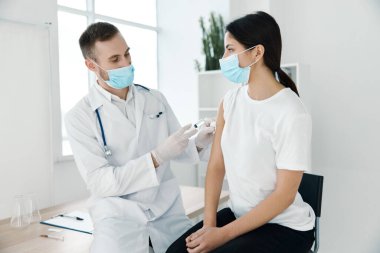 Önlüklü doktor ve koruyucu maske takan şırınga enfeksiyonu laboratuvar aşısı hastanesi kovid 