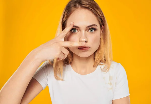 Um gesto louro bonito com as mãos para um rosto em um fundo amarelo um gesto positivo — Fotografia de Stock