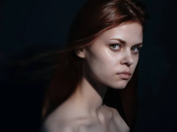 Mujer con una mirada interesada en un modelo de vista lateral de fondo oscuro — Foto de Stock