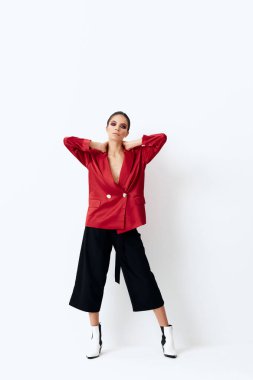 Kırmızı ceketli şık bir kadın başının arkasında el ele tutuşup izole bir arka plan oluşturuyor.