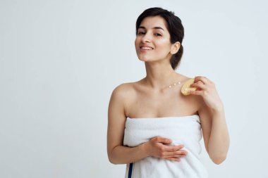 Ellerinde süngerle güzel bir esmer beyaz havlular temiz cilt bakımı