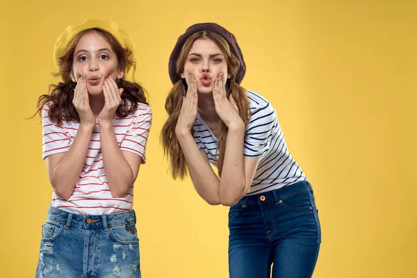 funny mom and daughter wearing hats fashion fun joy family yellow background