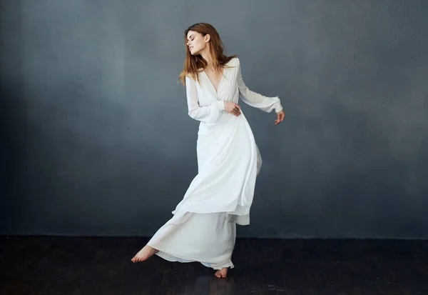 Retrato de una mujer atractiva en un vestido blanco sobre un fondo gris en pleno crecimiento Copiar espacio — Foto de Stock