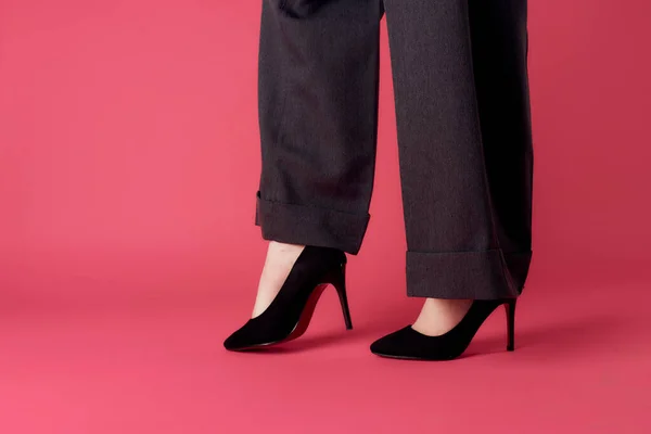 Kvinnliga ben svarta skor glamour lyx rosa bakgrund beskärd utsikt — Stockfoto