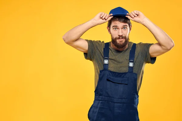 Hombre trabajador en uniforme servicio de entrega profesional fondo amarillo — Foto de Stock