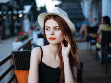 Sokak kafesinde güzel bir kadın. Manken restoran duyguları. Şapka.