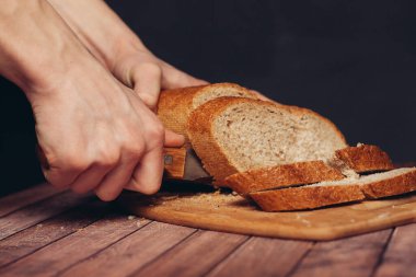 Tahta kesme tahtasında taze ekmek dilimliyorum.