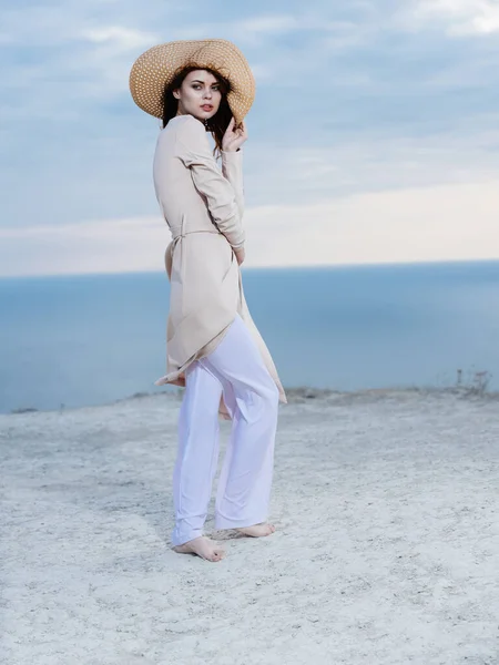 Όμορφη γυναίκα φορώντας ελαφρά ρούχα στην άμμο κοντά στον ωκεανό στη φύση — Φωτογραφία Αρχείου