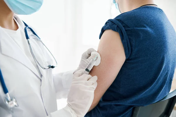 Kvinna läkare som ger en injektion i axeln patient laboratorieassistent vaccin — Stockfoto