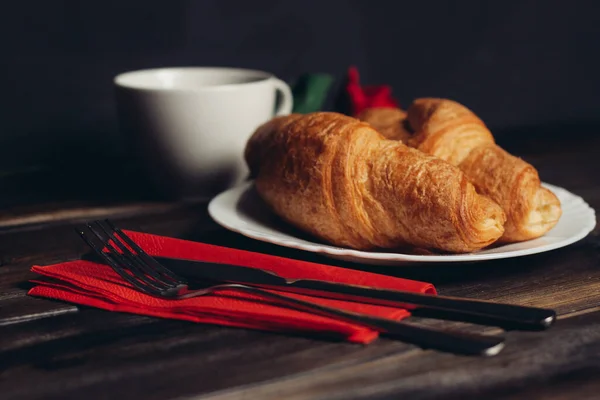 Krispiga croissanter på tallrik träbord kaffemugg — Stockfoto