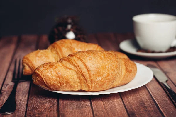 Krispiga croissanter på en tallrik köksredskap till frukost — Stockfoto