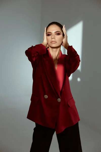Mulher atraente segurando rosto vermelho jaqueta moda — Fotografia de Stock