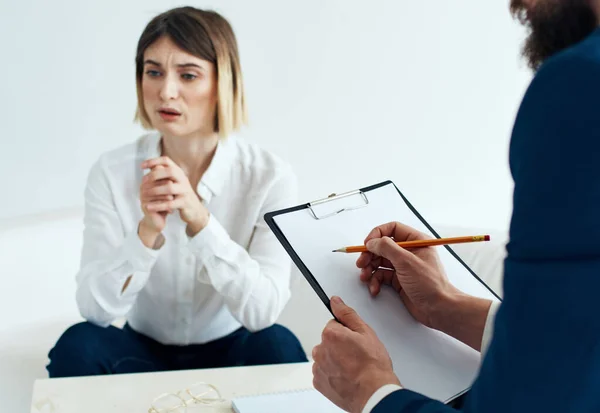 Una mujer en el sofá de un psicólogo en la recepción y un hombre con documentos — Foto de Stock