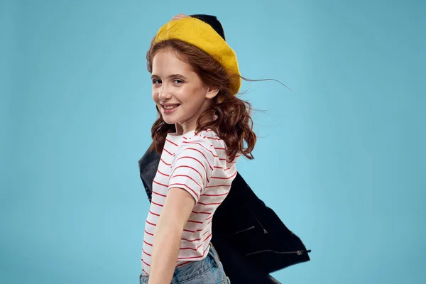 Vrolijk schattig meisje in gele hoed kleding studio blauwe achtergrond — Stockfoto