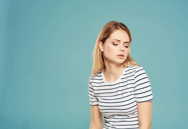 Traurige Frau im T-Shirt auf blauem Hintergrund — Stockfoto