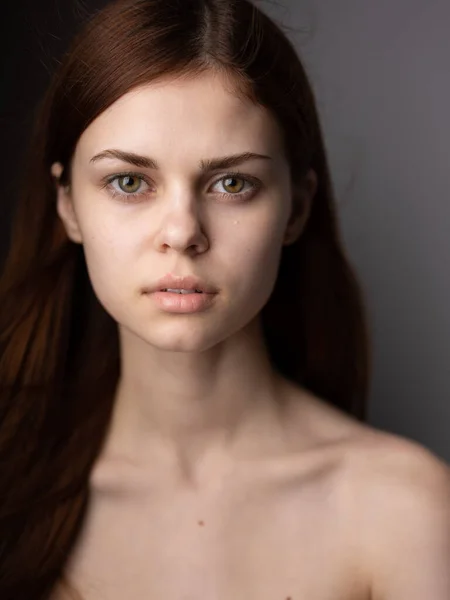 Portret van een mooie vrouw met blote schouders rood haar close-up grijs achtergrond bijgesneden uitzicht — Stockfoto