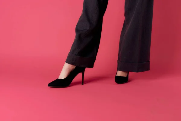 Mujeres piernas elegantes zapatos negros moda fondo rosa — Foto de Stock