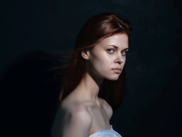 Mulher com um olhar interessado em um modelo de vista lateral de fundo escuro — Fotografia de Stock
