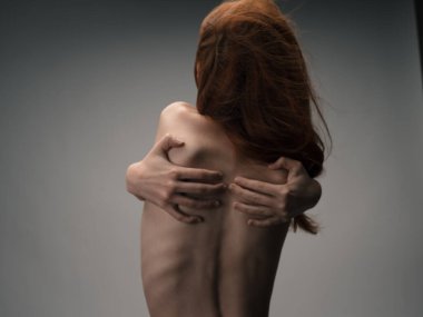 Zayıf bir kadın duygu modeliyle elleriyle kendisine dokunuyor.