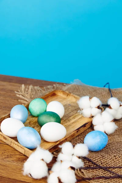 Huevos de colores en la celebración del tablero de madera dinero cristiano fondo azul —  Fotos de Stock