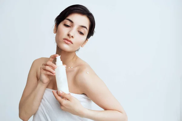 Ganska brunett med bara axlar lotion i händerna hudvård närbild — Stockfoto