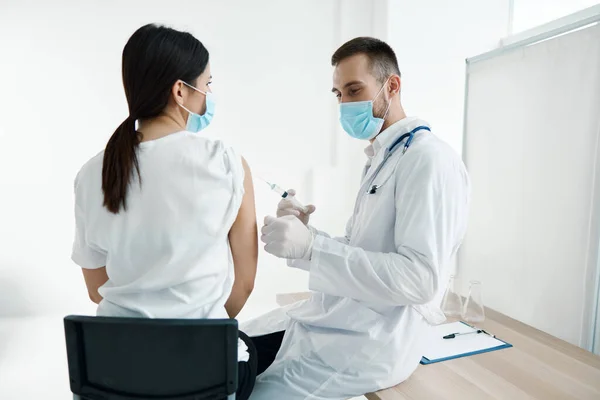 Medico in un abito medico e in una siringa protettiva maschera infezione fiala con vaccino — Foto Stock