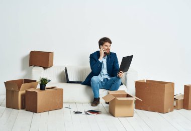 İş adamı kanepede oturmuş telefon kulübesinde konuşuyor.