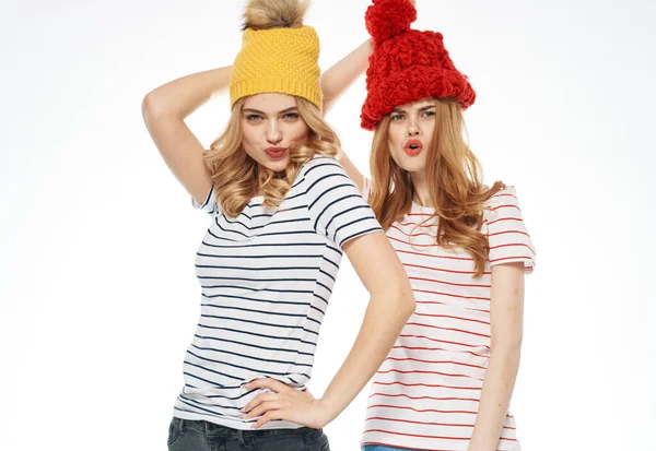 Δύο γυναίκες ριγέ t-shirts πολύχρωμα καπέλα συναισθήματα διασκέδαση στούντιο μόδας χαρά — Φωτογραφία Αρχείου