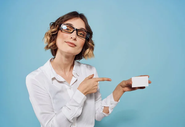 Ellerinde beyaz antetli kadın gömlek gözlüklü saç stili mavi arka plan — Stok fotoğraf