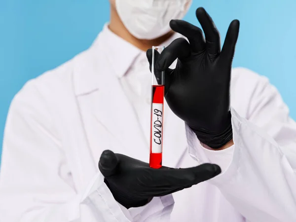 Чоловічий лабораторний асистент в захисному костюмі тест на кров чорні рукавички крупним планом wovid-19 — стокове фото