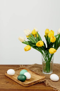 Yellow tulips painted eggs easter holiday decoration