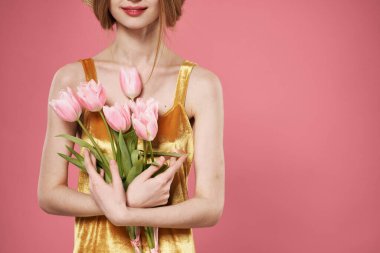 Çiçek buketi olan bir kadın. 8 Mart, pembe arka plan.