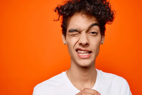 Cara com cabelo encaracolado em um branco t-shirt emoção grimace — Fotografia de Stock