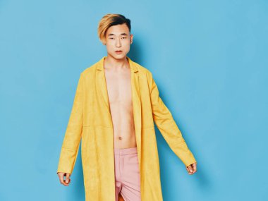 Mavi arka planda kırmızı çiçekli Asyalı adam ve sarı ceketli moda tarzı.