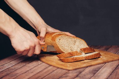 Kesme tahtasındaki taze bir somunu dilimliyorum.