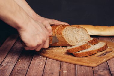 Kesme tahtasındaki taze bir somunu dilimliyorum.