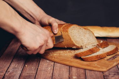 Kesme tahtasındaki taze bir somunu dilimliyorum.