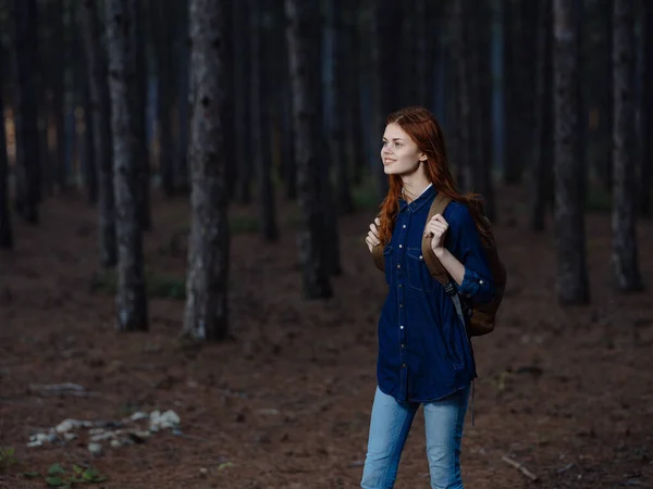 Turista mujer con una mochila en la espalda camina por la naturaleza en el bosque —  Fotos de Stock