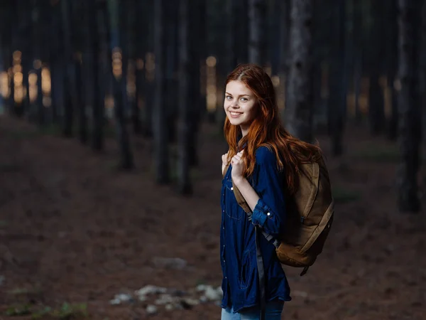 Kvinde Turist med en rygsæk på ryggen går på naturen i skoven - Stock-foto