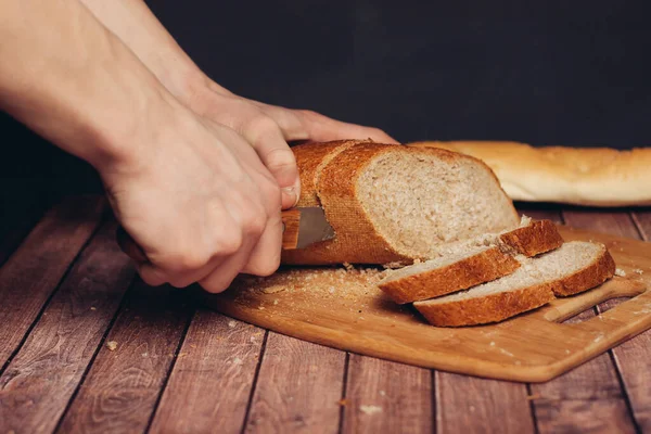 Friss kenyeret szeletelni a vágódeszkán evés közben — Stock Fotó