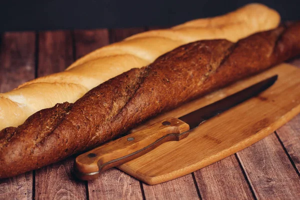 Szeletelt friss kenyér fából készült vágódeszkás konyhai ételen — Stock Fotó