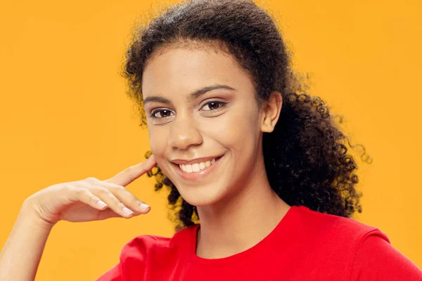 Mulher feliz em t-shirt vermelha no fundo amarelo sorriso vista cortada — Fotografia de Stock