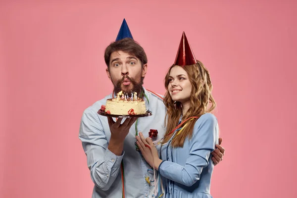 Party muž a žena korporátní růžové pozadí zábava dort čepice — Stock fotografie