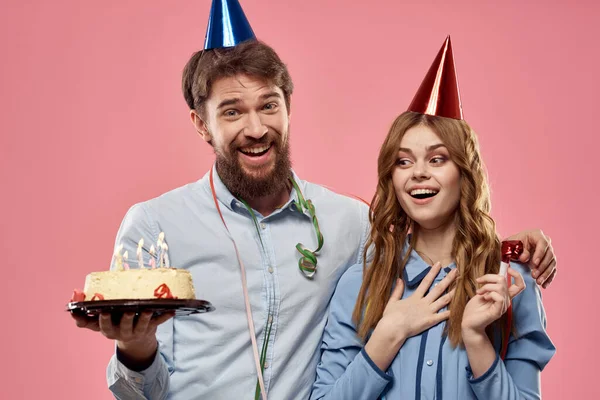 Party man and woman with cake on pink background corporate birthday