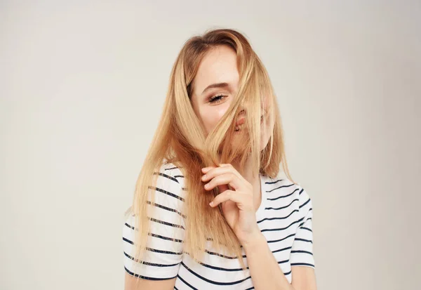 Mulher loira em t-shirt listrada no fundo bege vista cortada — Fotografia de Stock