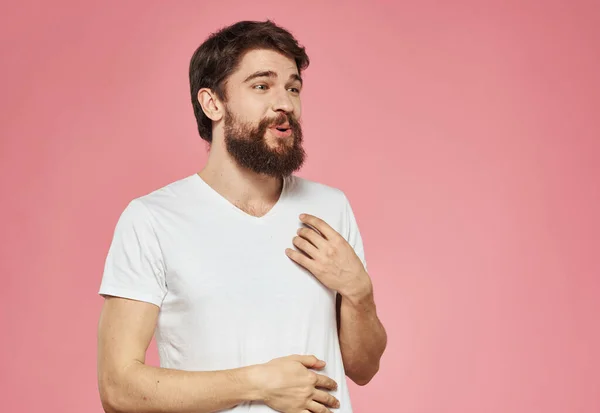 Følelsesmessig mann som gestikulerer med hendene på en rosa bakgrunn – stockfoto